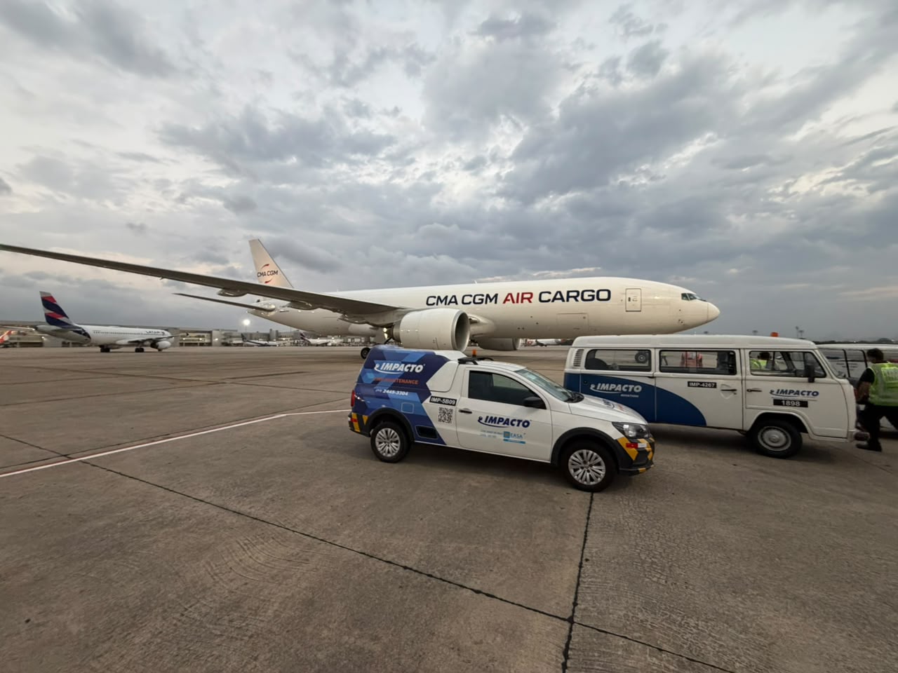 Impacto Aviation vehicles on the ramp next to a CMA CGM Air Cargo aircraft