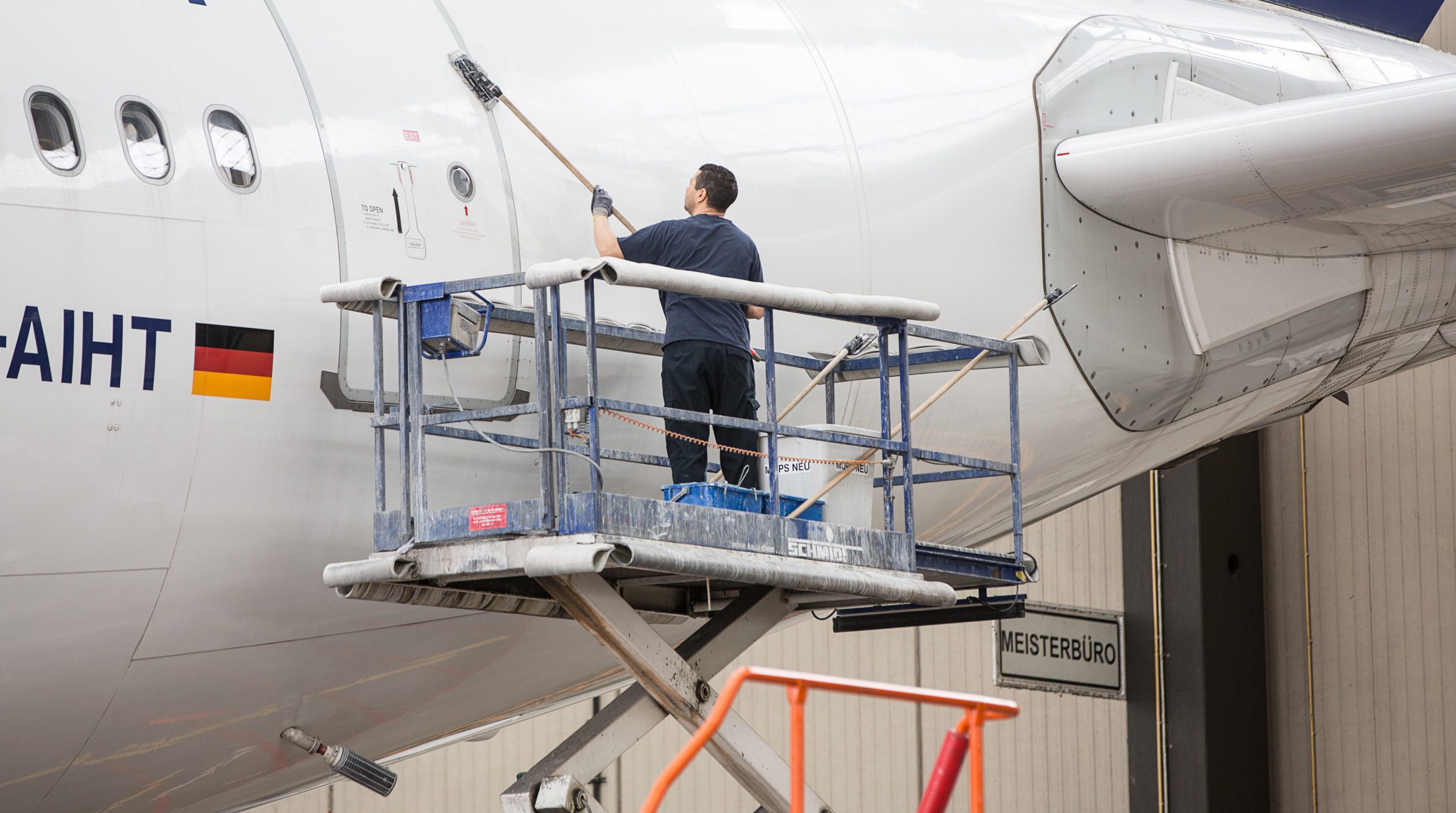 Technician performing an exterior aircraft wash from an elevated platform